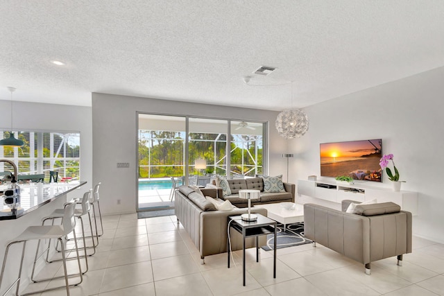 living room with visible vents, a healthy amount of sunlight, light tile patterned flooring, and a sunroom