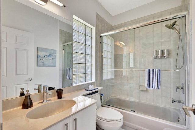 bathroom with shower / bath combination with glass door, toilet, and vanity