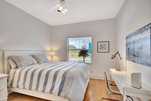 bedroom featuring baseboards, a ceiling fan, and light wood-style floors