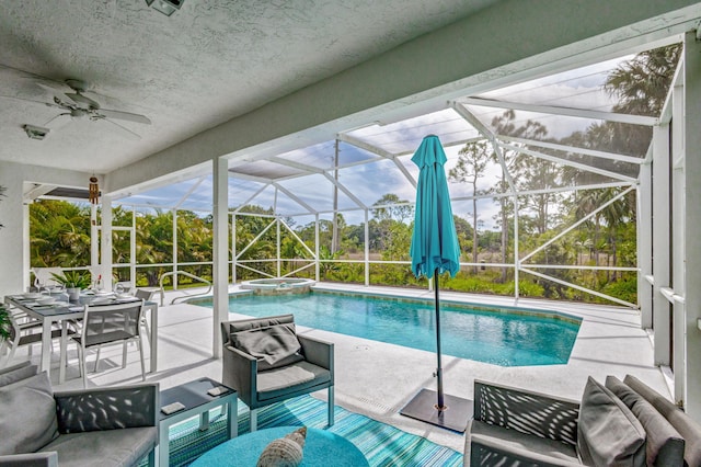 view of swimming pool with a ceiling fan, a lanai, a patio area, and a pool with connected hot tub