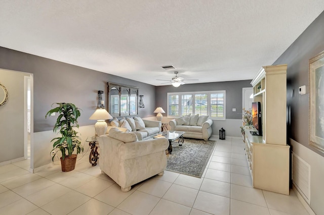 living room featuring a healthy amount of sunlight, light tile patterned floors, ceiling fan, and visible vents