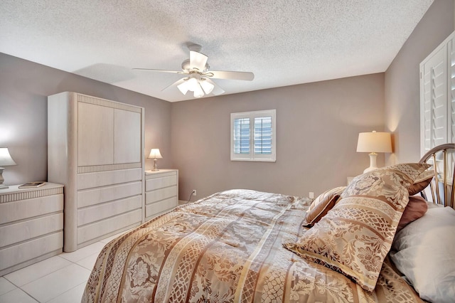 bedroom with light tile patterned floors, ceiling fan, and a textured ceiling