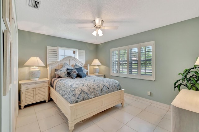 bedroom featuring a textured ceiling, ceiling fan, light tile patterned floors, and visible vents