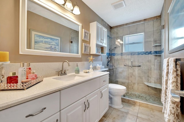 bathroom featuring visible vents, toilet, a textured ceiling, a shower stall, and vanity