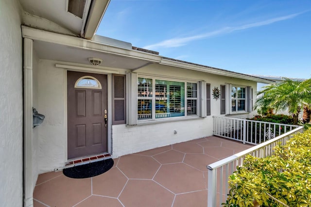 view of exterior entry featuring a patio area