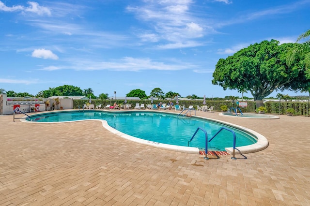 community pool featuring a patio, a community hot tub, and fence