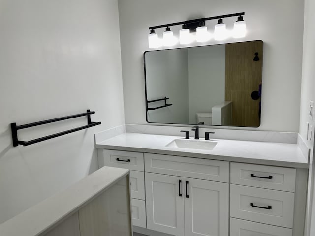 half bath featuring toilet and vanity