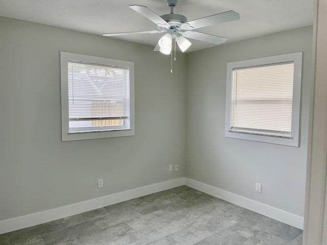 unfurnished room featuring a ceiling fan and baseboards