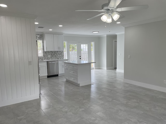 kitchen featuring ornamental molding, white cabinets, light countertops, decorative backsplash, and dishwasher