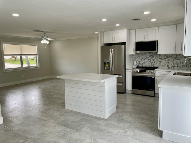 kitchen featuring a sink, stainless steel appliances, white cabinets, light countertops, and decorative backsplash