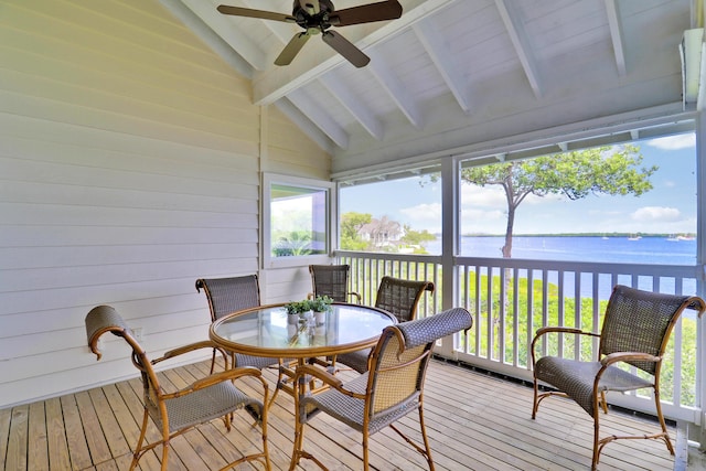 sunroom / solarium featuring a ceiling fan, a water view, and lofted ceiling with beams