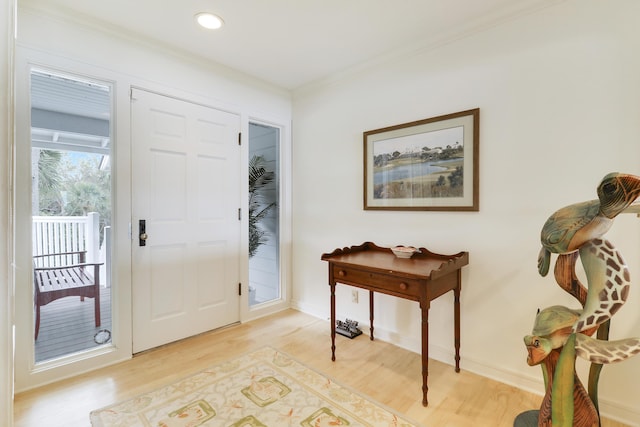 foyer entrance with ornamental molding, recessed lighting, light wood-style flooring, and baseboards