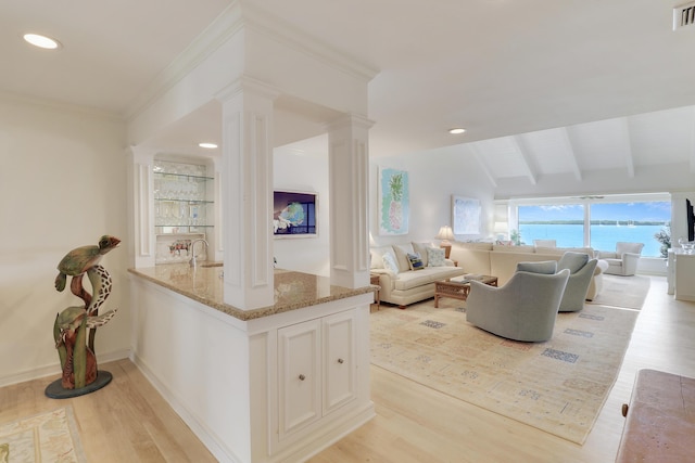 living room featuring vaulted ceiling with beams, decorative columns, visible vents, and light wood-style flooring