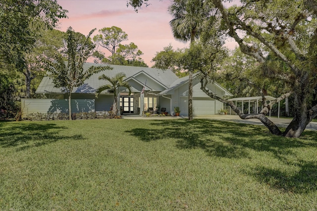 view of front of house featuring a garage, driveway, and a front lawn