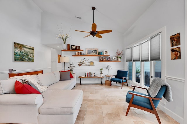 living area featuring high vaulted ceiling, stone finish floor, visible vents, and baseboards