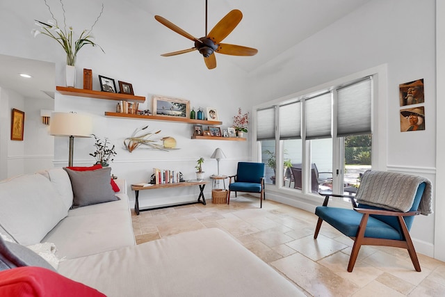 living area featuring ceiling fan, recessed lighting, stone tile floors, a towering ceiling, and baseboards