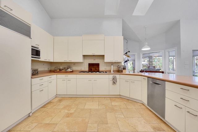 kitchen featuring high vaulted ceiling, appliances with stainless steel finishes, decorative backsplash, and decorative light fixtures