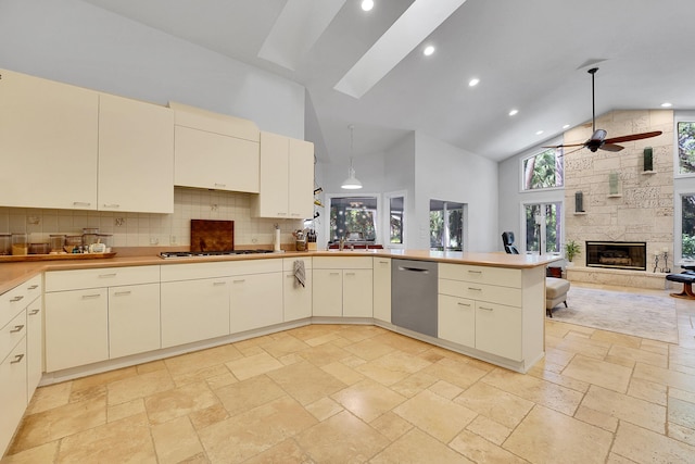 kitchen featuring a ceiling fan, cream cabinets, high vaulted ceiling, stainless steel dishwasher, and gas cooktop