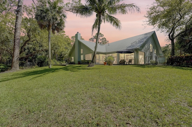 exterior space with a chimney and a front lawn