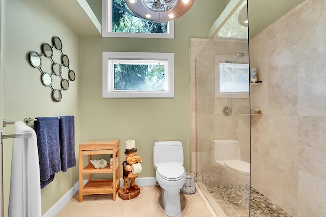 bathroom with a walk in shower, tile patterned floors, toilet, and baseboards