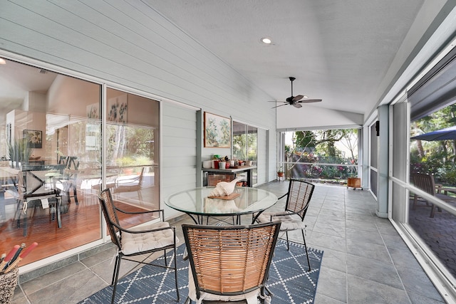 sunroom with vaulted ceiling and a ceiling fan