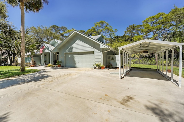 view of front facade with a garage, a carport, fence, and driveway