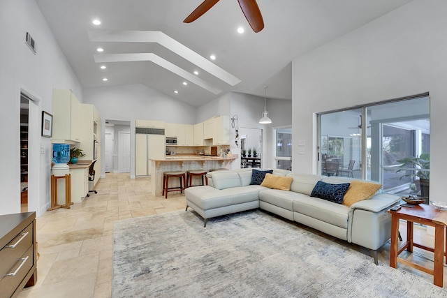 living area with high vaulted ceiling, stone tile flooring, visible vents, and a ceiling fan