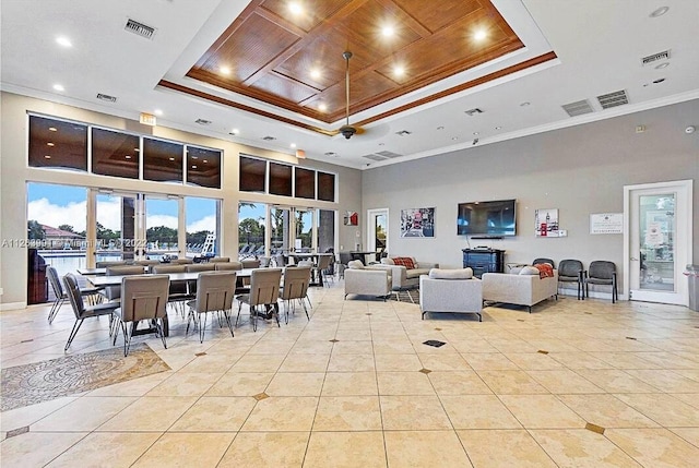 dining space with a raised ceiling, light tile patterned flooring, visible vents, and ornamental molding