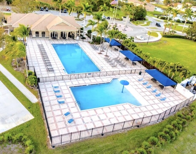 pool featuring a patio area, a lawn, and fence