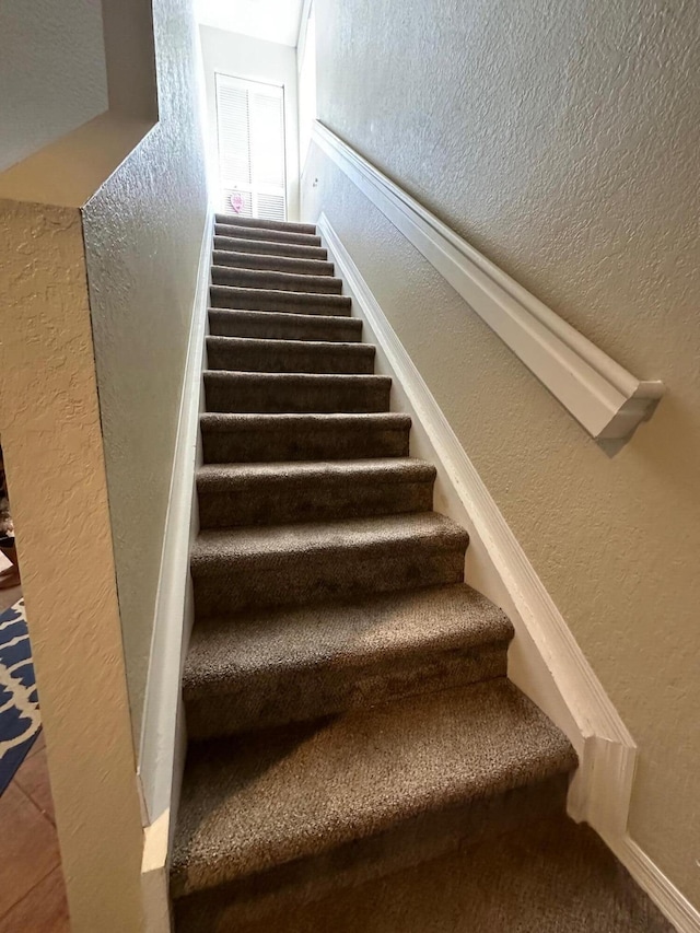 stairs featuring a textured wall