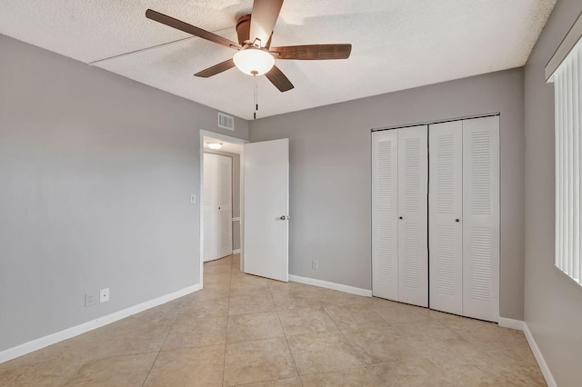 unfurnished bedroom featuring baseboards, visible vents, a closet, and tile patterned floors