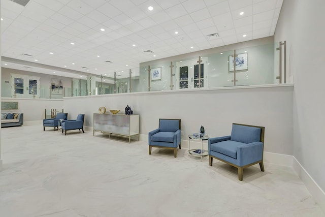 sitting room with recessed lighting, a drop ceiling, and baseboards