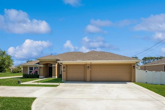 view of front facade with a front lawn, fence, stucco siding, a garage, and driveway