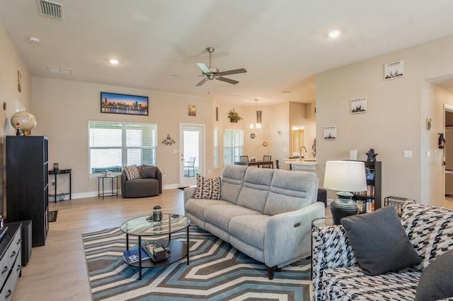 living area with visible vents, baseboards, recessed lighting, light wood-style floors, and a ceiling fan