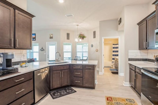 kitchen featuring dark brown cabinetry, light countertops, plenty of natural light, stainless steel appliances, and a sink