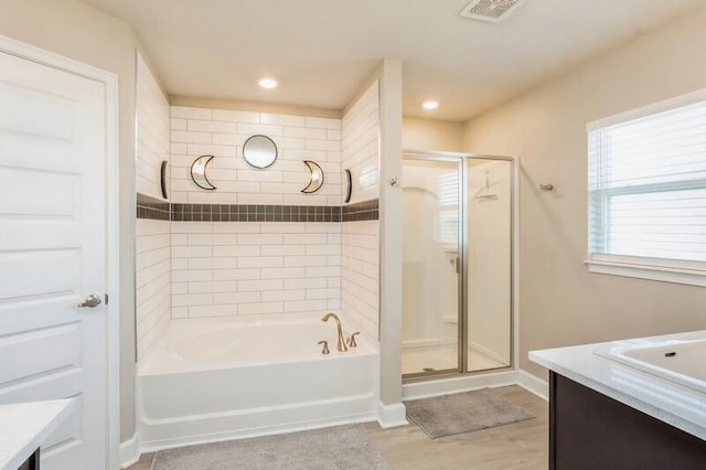 full bath with visible vents, a tub to relax in, a shower with door, wood finished floors, and vanity