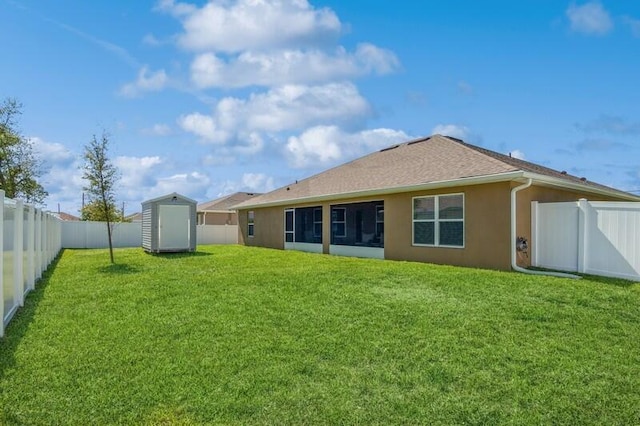 back of property with a lawn, stucco siding, an outdoor structure, a fenced backyard, and a storage unit