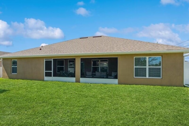 rear view of property with a lawn, a sunroom, and stucco siding