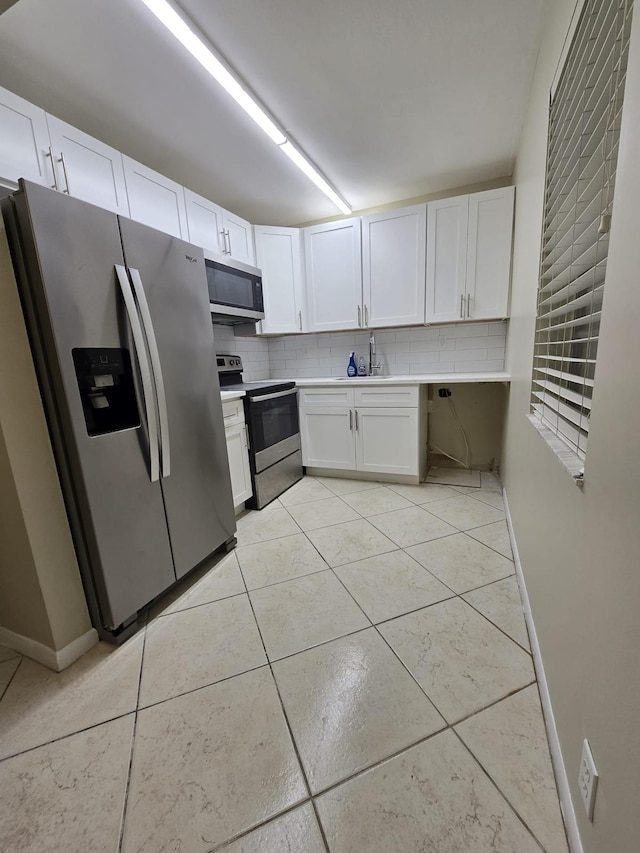 kitchen with light tile patterned floors, decorative backsplash, appliances with stainless steel finishes, and light countertops