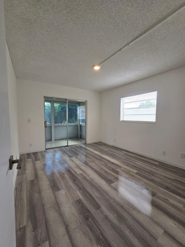 774 Burgundy Q, Delray Beach, FL 33484 - empty room with a textured ceiling, a healthy amount of sunlight, and wood finished floors