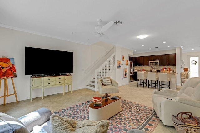 living area with light tile patterned floors, visible vents, crown molding, and stairs