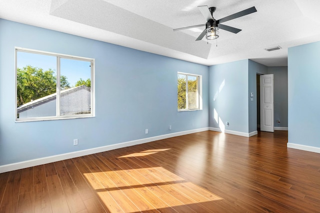 spare room featuring visible vents, a textured ceiling, and hardwood / wood-style flooring