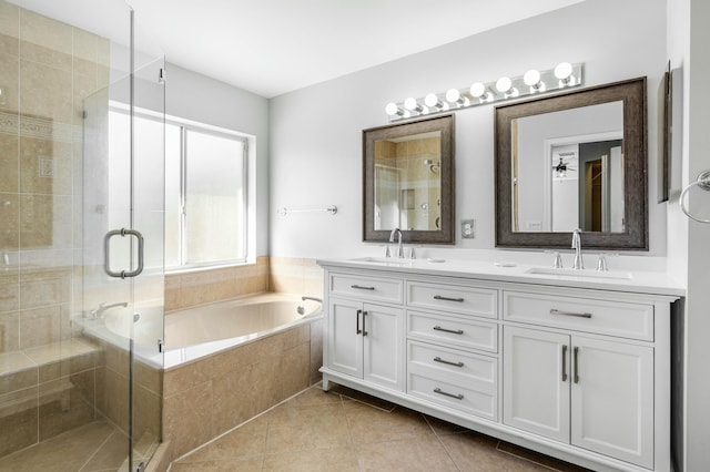 bathroom with tile patterned floors, a bath, a shower stall, and a sink