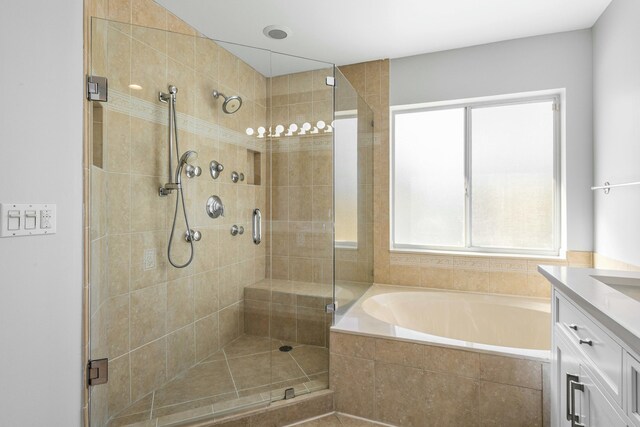 full bath featuring vanity, a shower stall, a garden tub, and a wealth of natural light