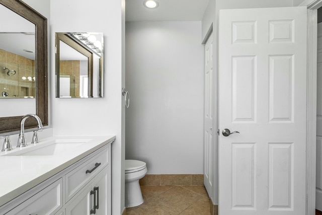 bathroom featuring baseboards, toilet, vanity, and tile patterned flooring