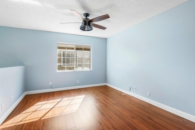 spare room featuring ceiling fan, baseboards, a textured ceiling, and wood finished floors