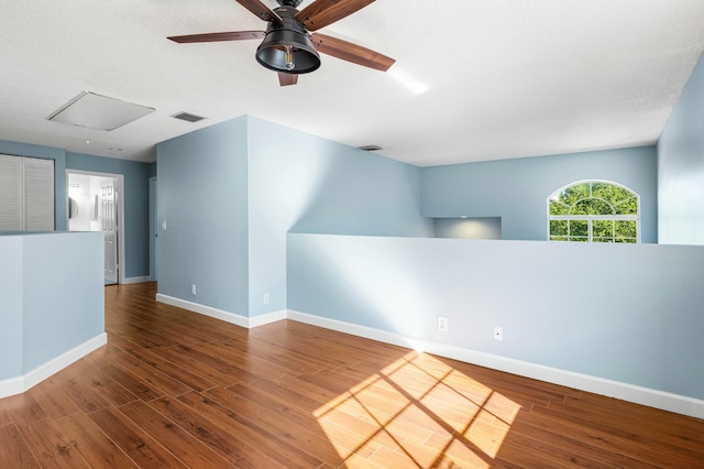 spare room with visible vents, a ceiling fan, a textured ceiling, wood finished floors, and baseboards