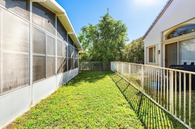 view of yard with a fenced backyard and a sunroom