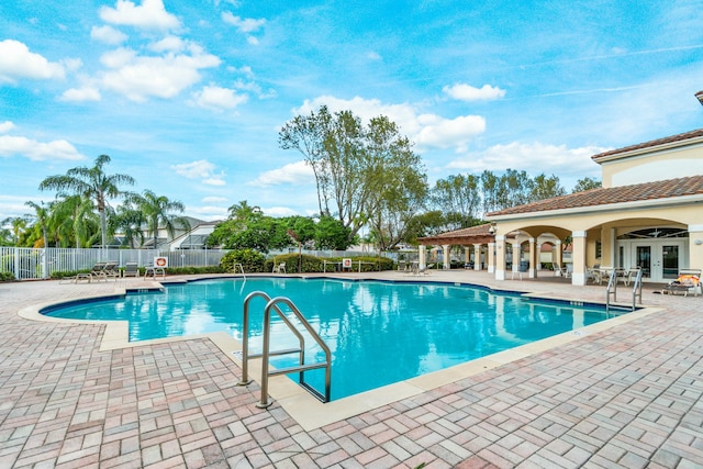 pool featuring a patio area, french doors, and fence