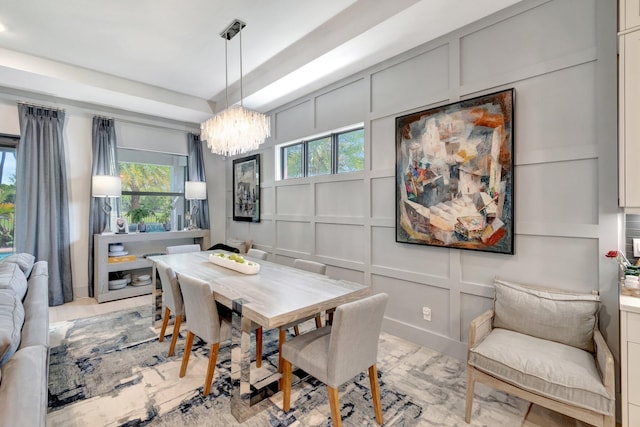 dining space featuring a notable chandelier and a decorative wall